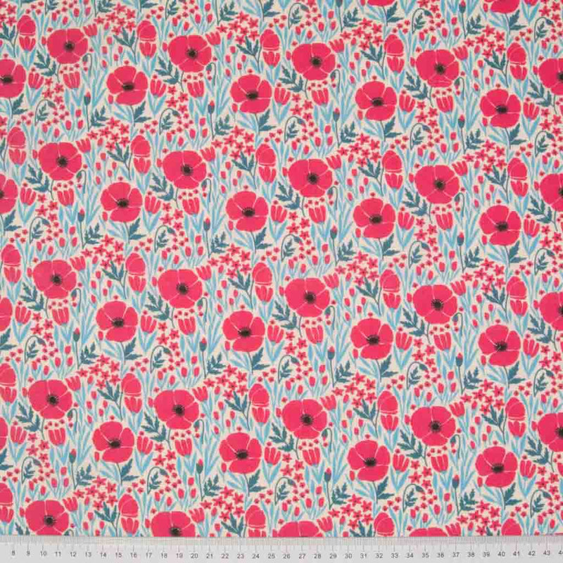 Small red poppies with teal coloured foliage are printed on a cream polycotton fabric with a cm ruler at the bottom