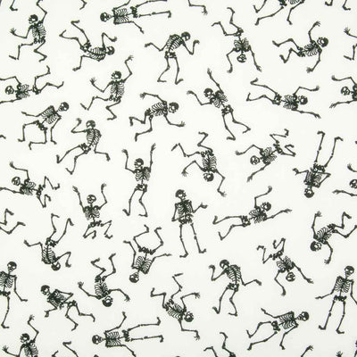 Black mini skeletons in a scattered pattern dancing on white polycotton halloween fabric