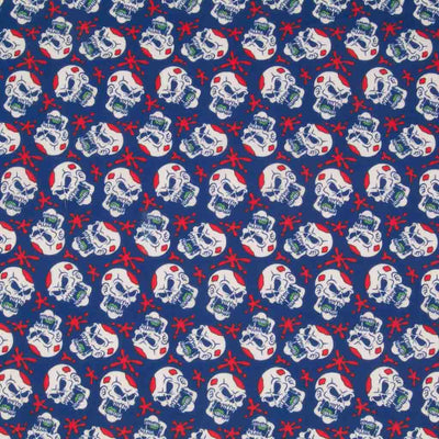 White screaming skulls and red paint splats printed on a blue halloween polycotton fabric