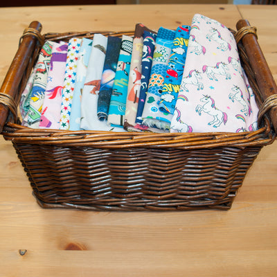 A wicker basket containing remnant pieces of children and kids printed cotton fabric
