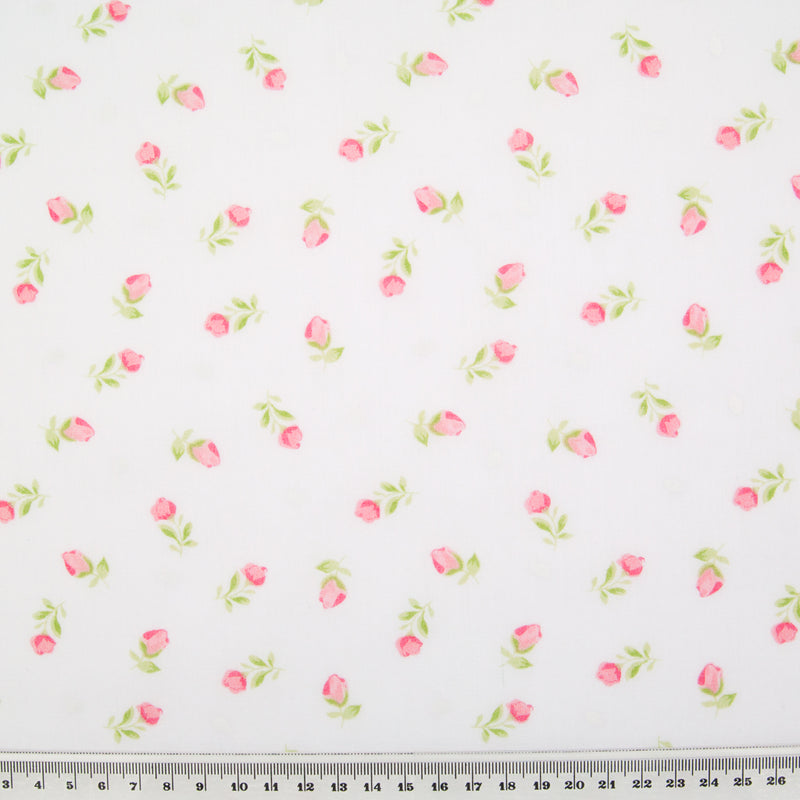 Pink baby rose flowers are printed in a scattered pattern on a white polycotton fabric with ruler for perspective