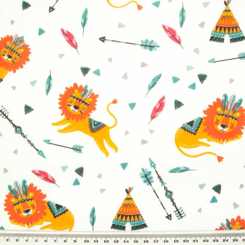 Orange sleeping lions, green feathers and stripy teepees printed on a white polycotton fabric with a ruler for size perspective