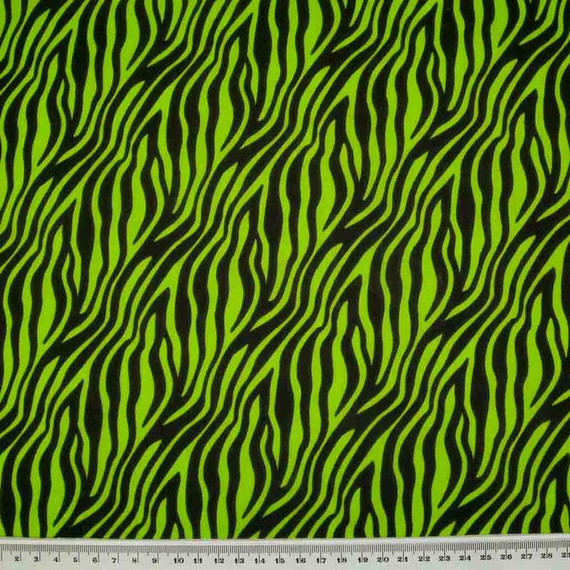 Zebra print polycotton fabric in green and black with a ruler at the bottom for size perspective