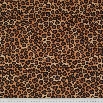 A natural coloured leopard print cotton fabric by Rose & Hubble with a cm ruler at the bottom