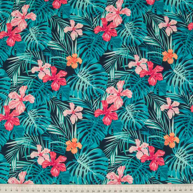Sunning aqua coloured palm leaves and pink lilies printed on a navy cotton poplin fabric by Rose & Hubble with a cm ruler at the bottom