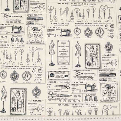 A french vintage sewing print featuring mannequins and dressmaking scissors on an ivory cotton fabric with a cm ruler at the bottom