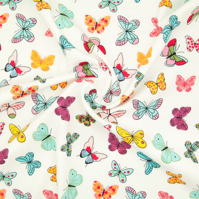 Brightly coloured Butterflies printed on cotton poplin fabric by Rose and Hubble with swirl for drape perspective