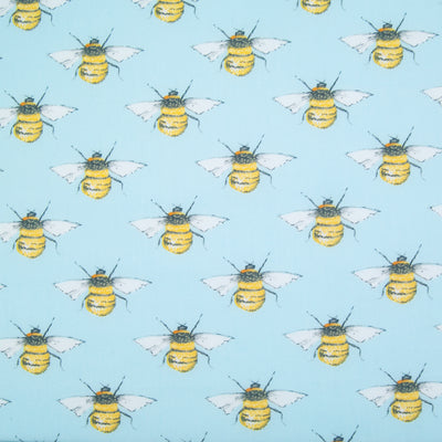 Large black and yellow bees in a geometric pattern on a flat piece of sky blue cotton poplin fabric