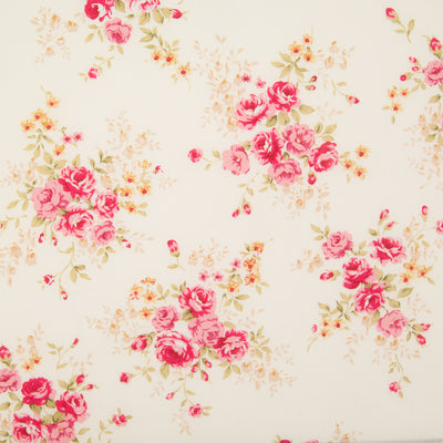 A fat quarter of small bouquets of pink roses on an ivory Rose & Hubble cotton poplin fabric