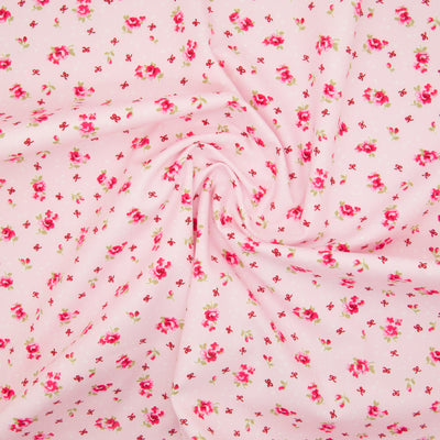 Rose and Hubble ditsy Alice rose on pink cotton fabric pictured in a swirl for drape perspective