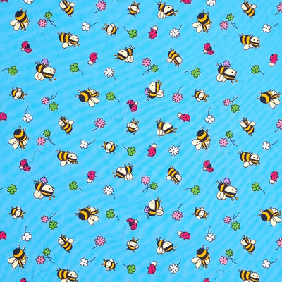 Bees, ladybirds and flowers are printed on a blue cotton poplin fabric by Rose & Hubble