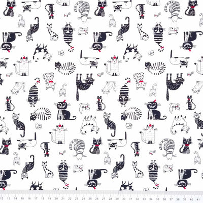 Black and white cats printed on a Rose & Hubble cotton poplin fabric with a cm ruler at the bottom