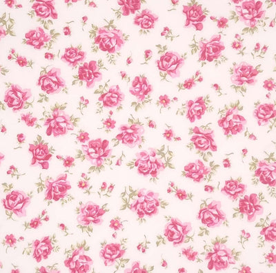 Dusky pink roses are printed on a sky ivory cotton poplin fabric by Rose & Hubble