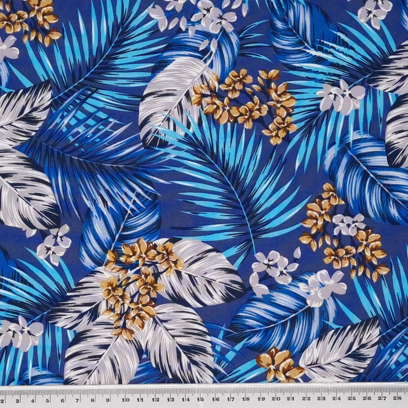 A Rose & Hubble floral design with tropical palm leaves on a blue, 100% cotton poplin fabric with a cm ruler