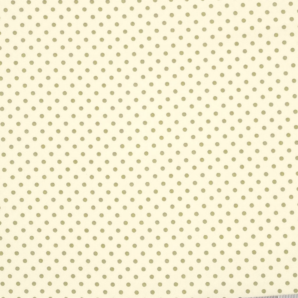 A 2mm mini spot in green is printed on a cream Rose & Hubble cotton poplin fabric