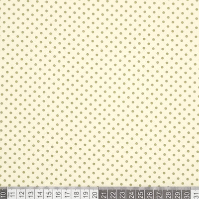 A 2mm mini spot in green is printed on a cream Rose & Hubble cotton poplin fabric with a cm ruler at the bottom