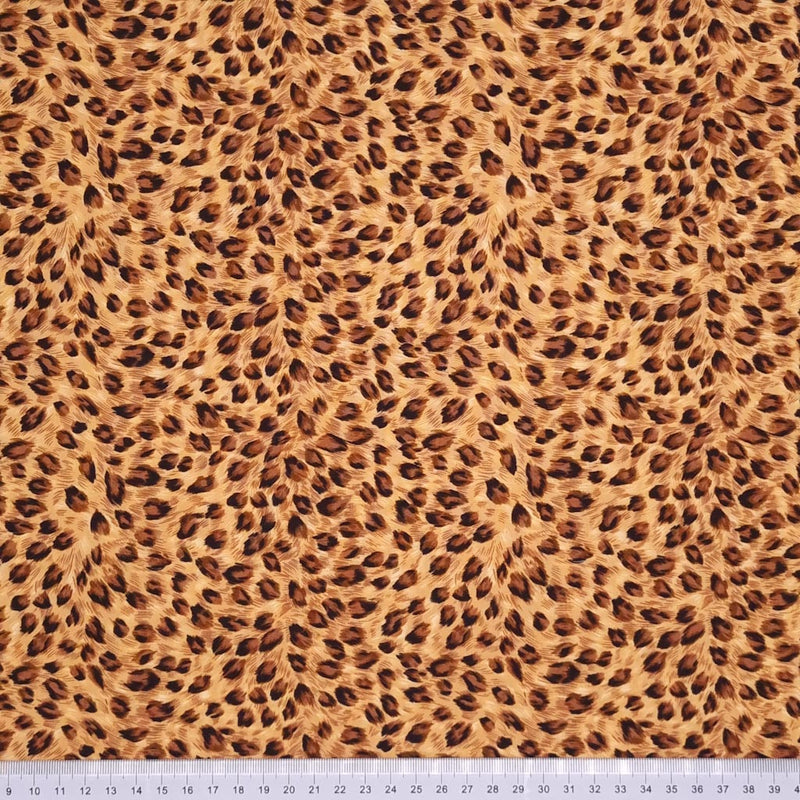An animal print in natural tones on a 100% cotton poplin fabric by Rose & Hubble with a cm ruler at the bottom
