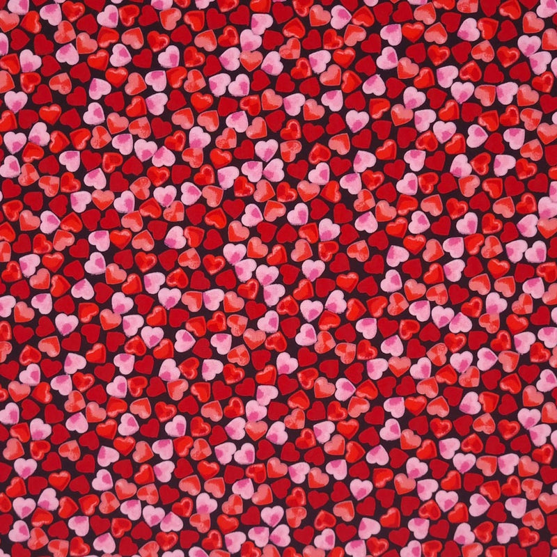 Small pink and red hearts are printed on a black, 100% cotton poplin by Rose & Hubble