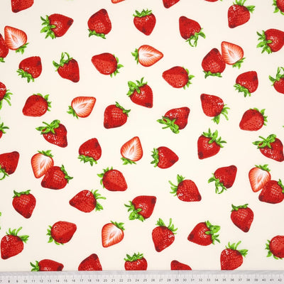 Juicy red strawberries printed on a cream cotton poplin fabric by Rose & Hubble with a cm ruler at the bottom