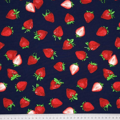 Juicy red strawberries printed on a navy cotton poplin by Rose & Hubble with a cm ruler at the bottom