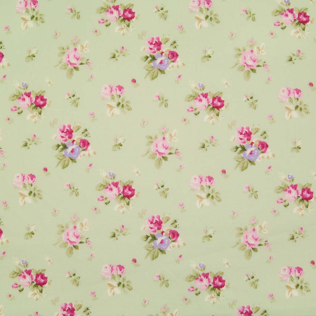 Small bouquets of pink roses are printed on a meadow green cotton poplin fabric