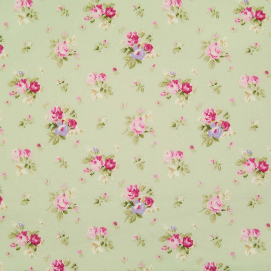 Small bouquets of pink roses are printed on a meadow green cotton poplin fabric