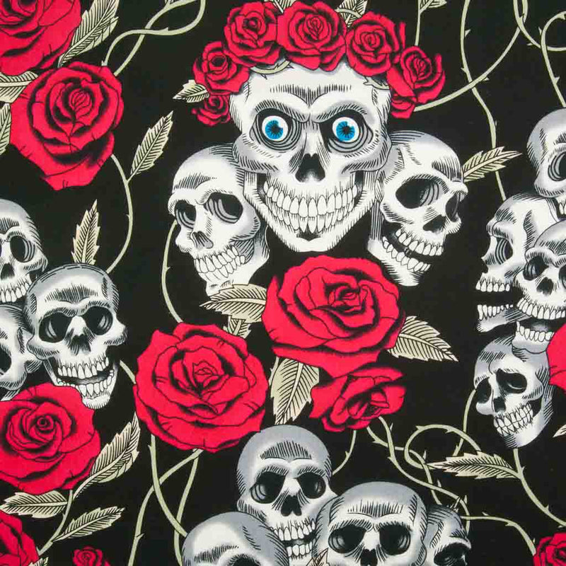 Gothic white skulls with blue eyes crowned with bright red roses are printed on a black 100% cotton poplin fabric by Rose and Hubble