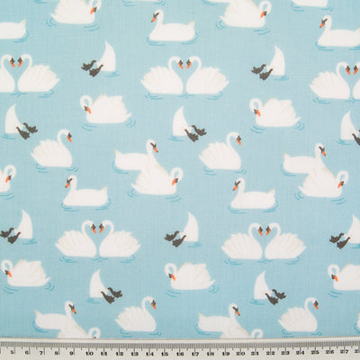 Swans printed on a blue polycotton fabric with a cm ruler