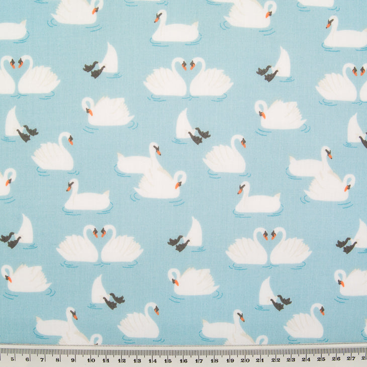 Swans printed on a blue polycotton fabric with a cm ruler