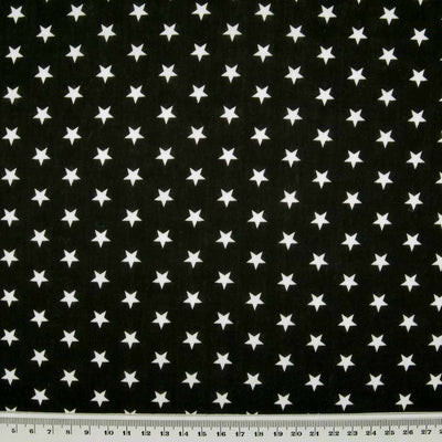 10mm white stars are printed on a black polycotton fabric with a cm ruler at the bottom