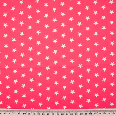 10mm white stars are printed on a cerise polycotton fabric with a cm ruler at the bottom