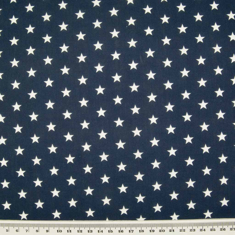 10mm white stars are printed on a navy blue polycotton fabric with a cm ruler at the bottom