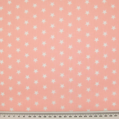 10mm white stars are printed on a pink polycotton fabric with a cm ruler at the bottom