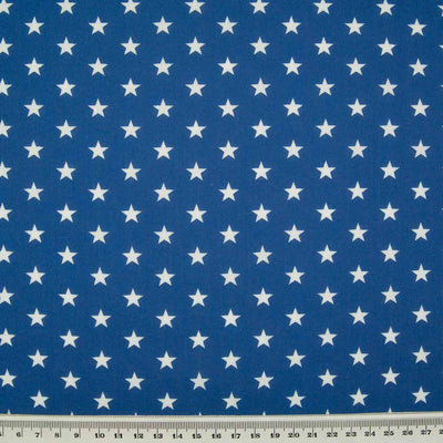 10mm white stars are printed on a royal blue polycotton fabric with a cm ruler at the bottom