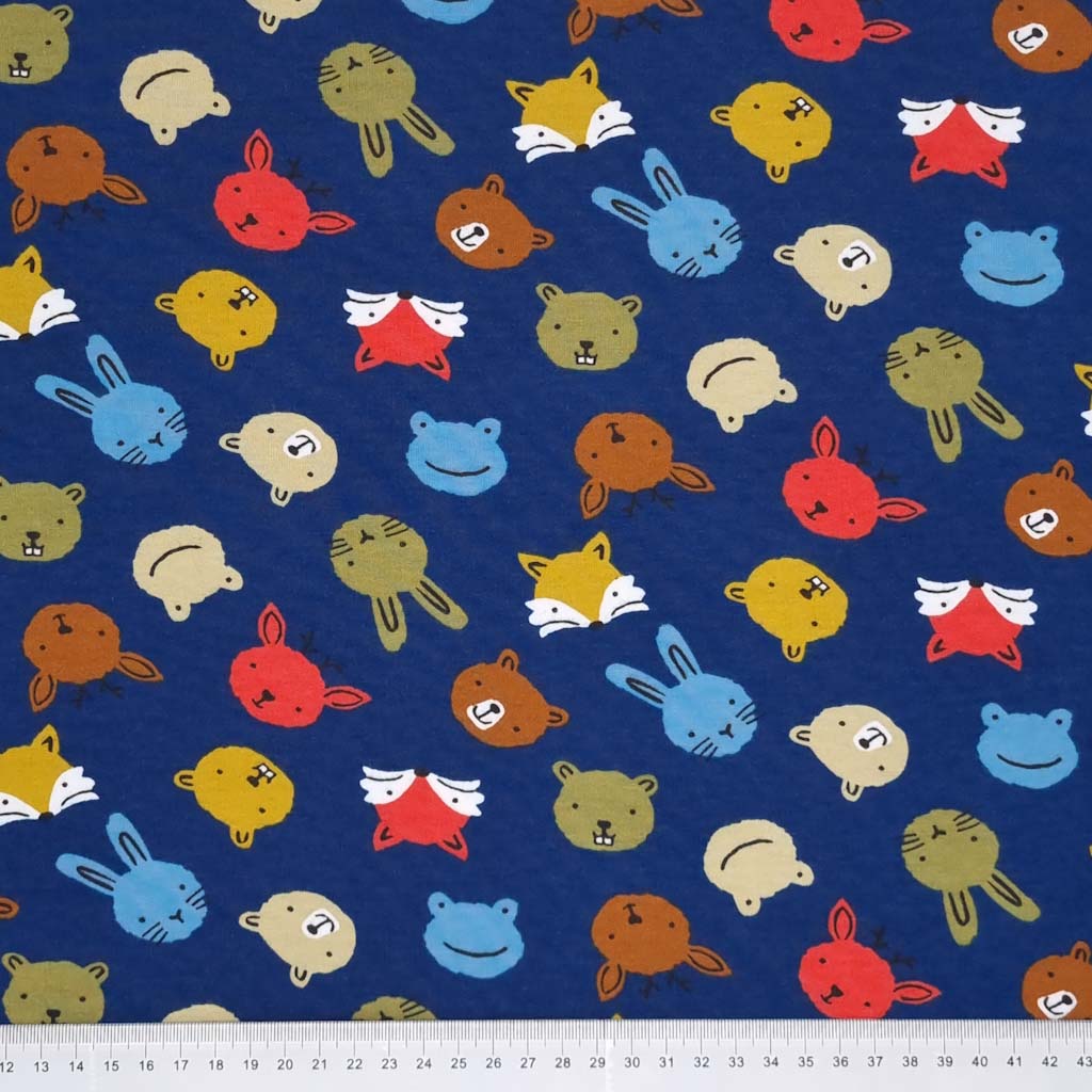 Animal faces are printed on a blue soft sweat cotton jersey fabric with a cm ruler at the bottom