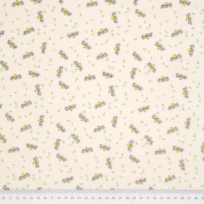 Bees and white daisies are printed on a cream polycotton fabric with a cm ruler at the bottom