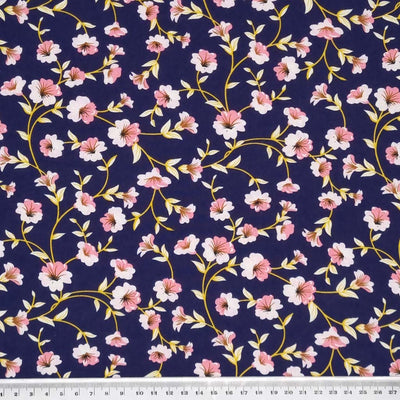 A delicate pink floral with a golden vine, printed on a navy, lightweight cotton poplin fabric with a cm ruler