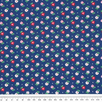 Tiny flowers in reds and pinks printed on a navy, lightweight cotton poplin fabric with a cm ruler