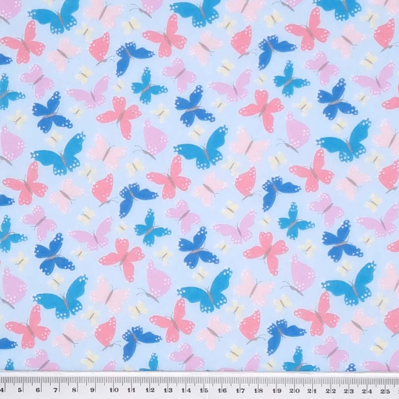 Pink and blue butterflies printed on a quality sky blue polycotton fabric with a cm ruler at the bottom