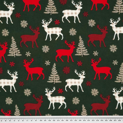 Red and cream check reindeer are printed on a green christmas cotton fabric with a cm ruler at the bottom
