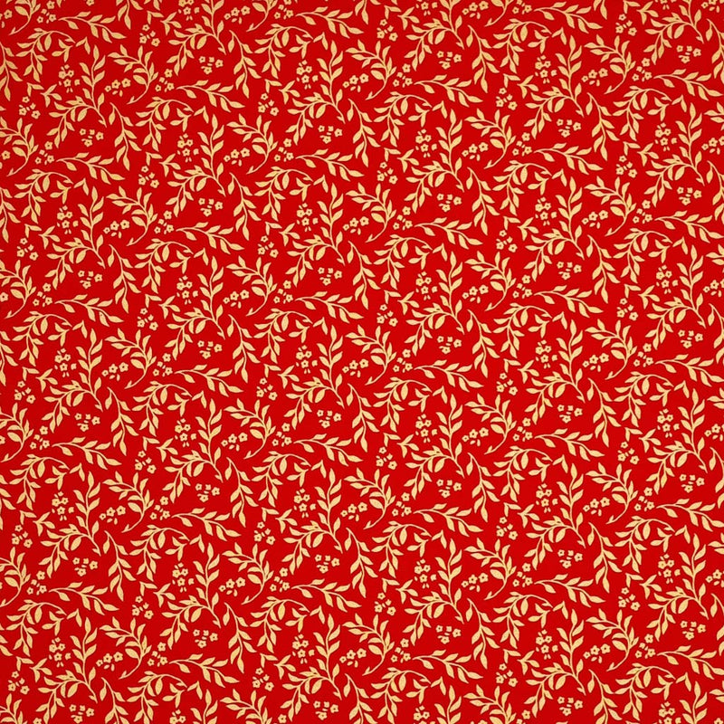 Printed gold metallic wreath leaves and flowers are printed on this red 100% cotton fabric