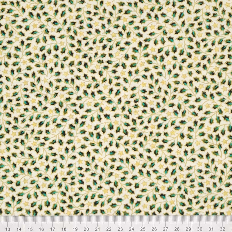 Mini holly leaves and stars in gold lacquer printed on an ivory christmas cotton fabric with a cm ruler