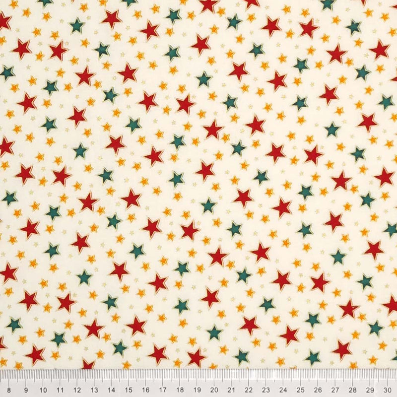 Red, green and gold stars with a metallic effect are printed on an ivory, 100% cotton fabric by Rose & Hubble with a cm ruler