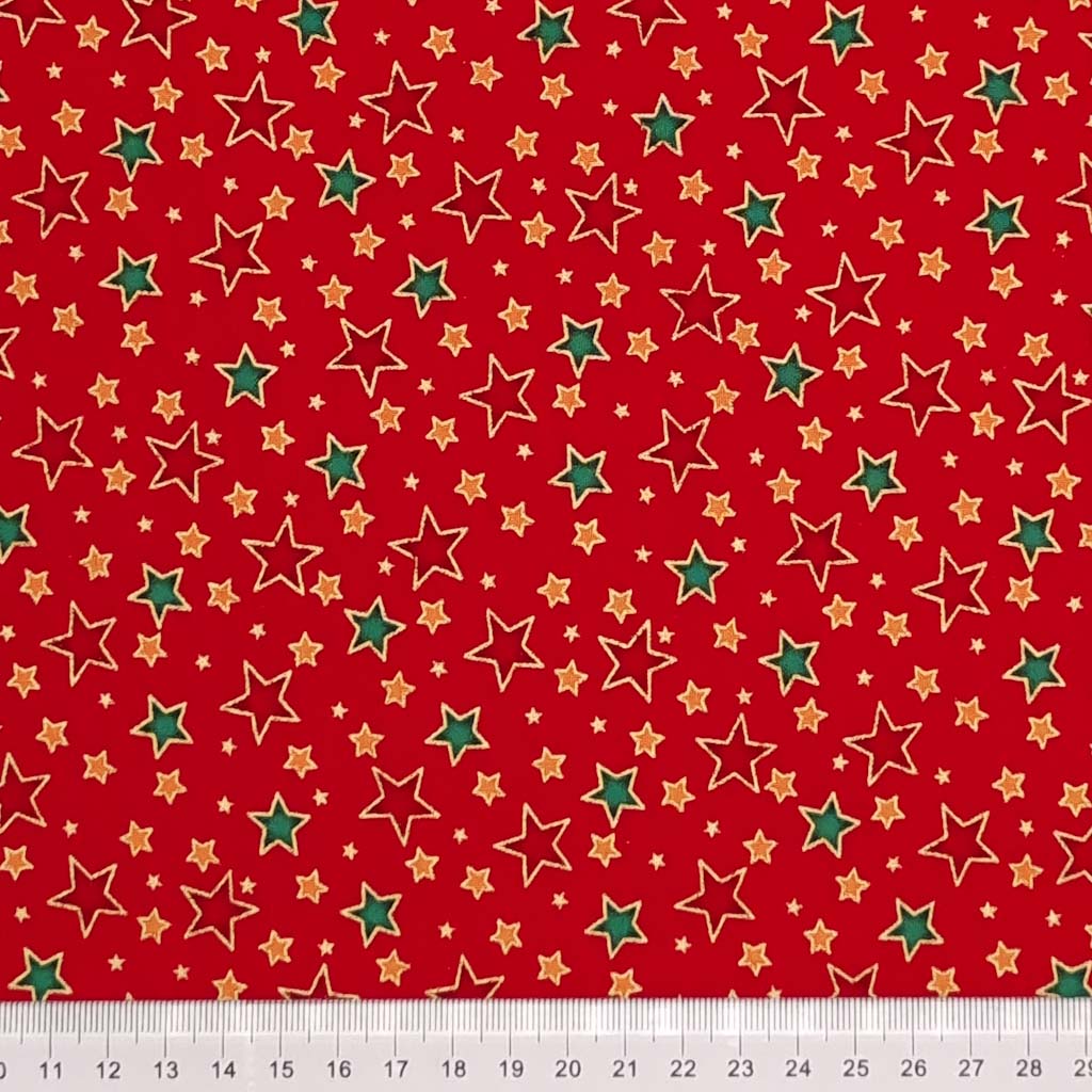 Red, green and gold stars with a metallic effect are printed on a red, 100% cotton fabric by Rose & Hubble with a cm ruler