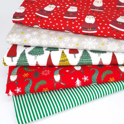 A christmas fat quarter bundle of 5 polycotton printed fabrics with Santa, trees and gonks