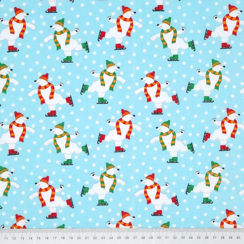 Happy skating polar bears are printed on an ice blue polycotton fabric with a cm ruler at the bottom