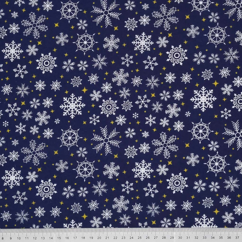 White snowflakes and gold stars on a navy polycotton fabric