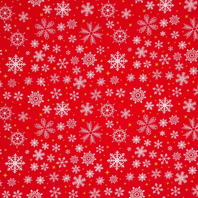 falling snowflakes and gold stars are printed on a red polycotton fabric