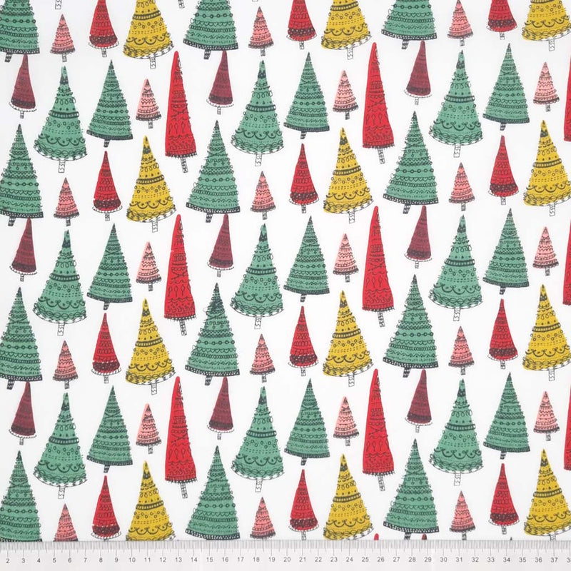 Intricate hand-drawn Christmas trees are printed on a white polycotton fabric with a cm ruler at the bottom