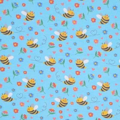 Smiling bees, flowers and hearts printed on a sky blue cotton jersey fabric